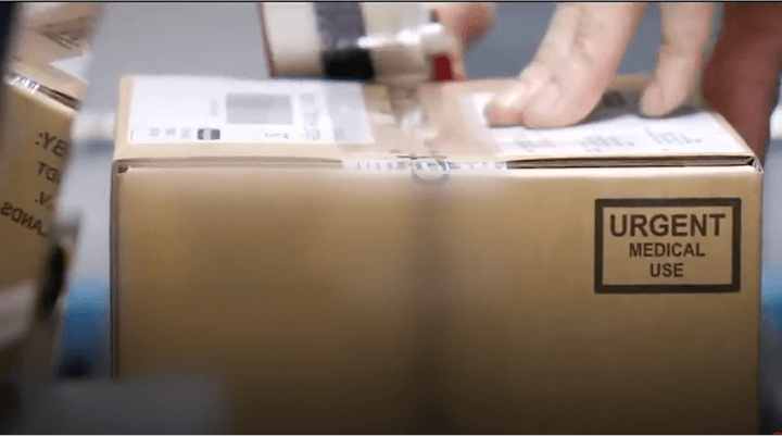 Box with an urgent medical use label getting taped for shipping.